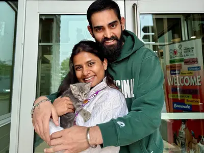 Man and woman holding kitten